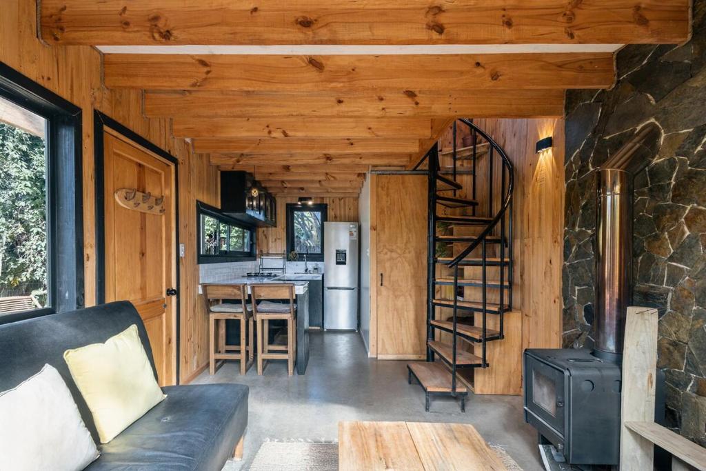 a living room with a couch and a spiral staircase at Casa full equipada Buchupureo in Buchupureo