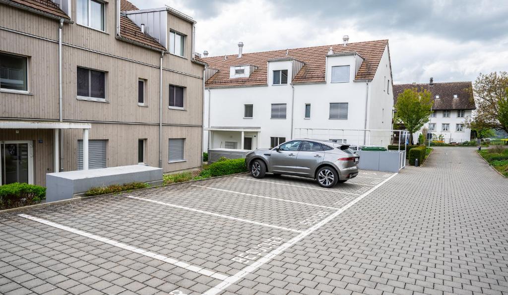 a car parked in a parking lot next to some buildings at Dingqin'Home in Arni Alp