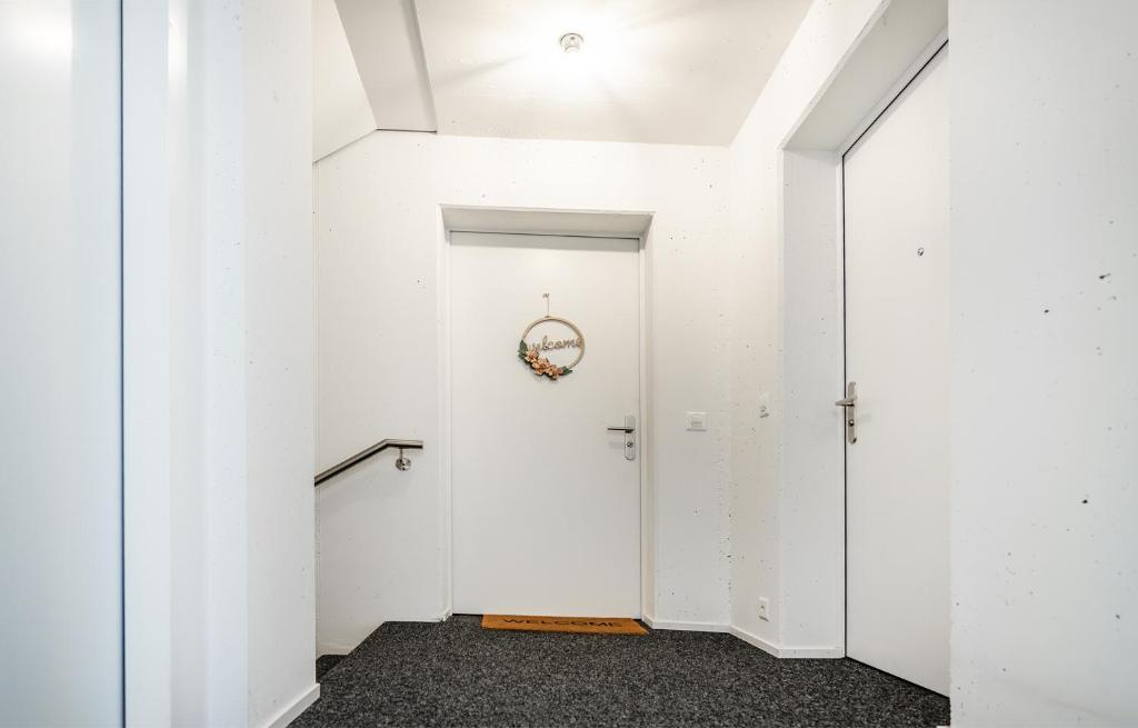 a hallway with white walls and a white door at Dingqin'Home in Arni Alp