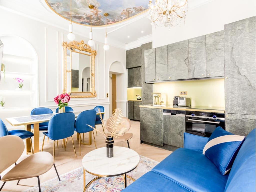 un salon avec un canapé bleu, une table et des chaises dans l'établissement Merveil - Luxury Suite -Opera - Volney I, à Paris
