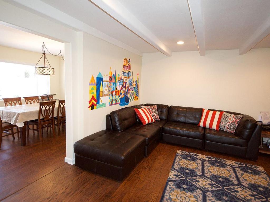 a living room with a leather couch and a dining room at F-30 Small World in Anaheim