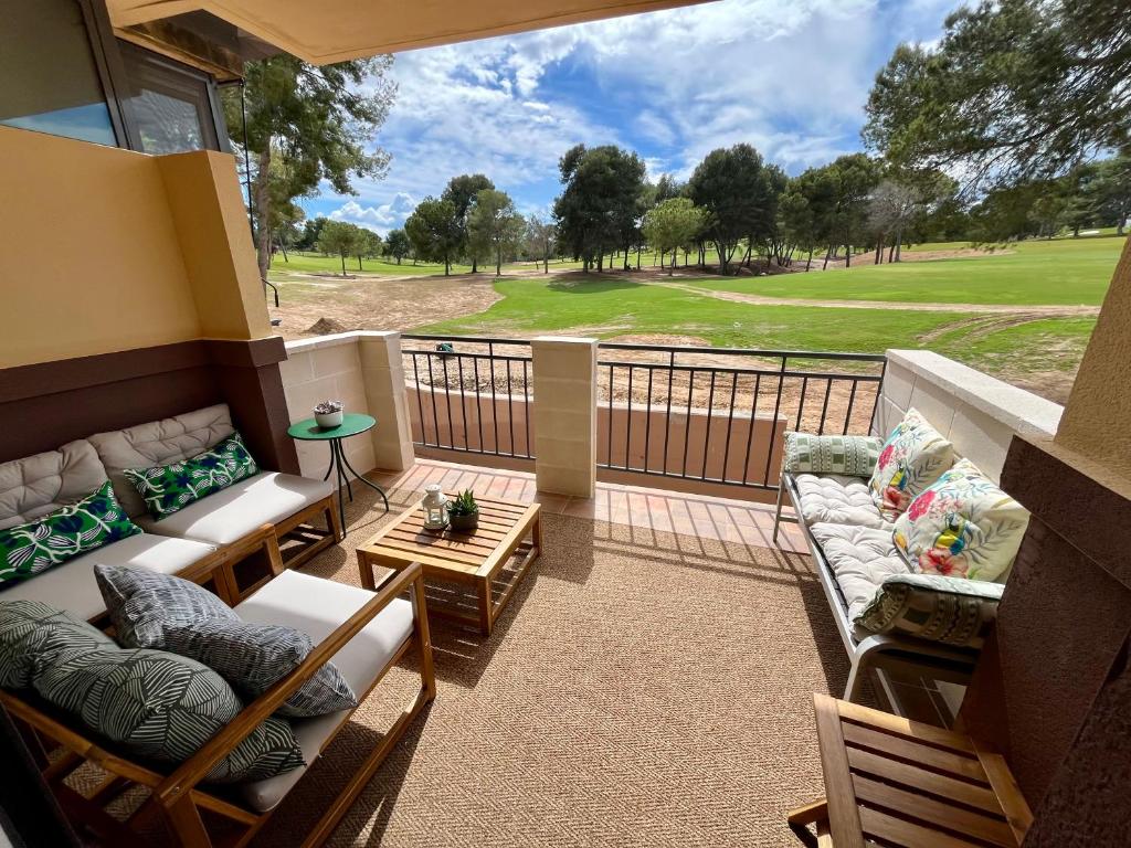 a balcony with couches and a view of a golf course at Casa Hoyo 19 in Masía Aldamar