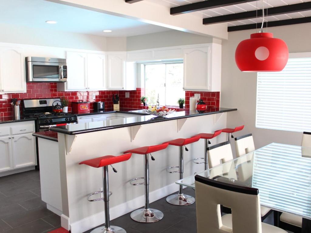 a kitchen with a counter with red stools at F-24 Mickeys House in Anaheim
