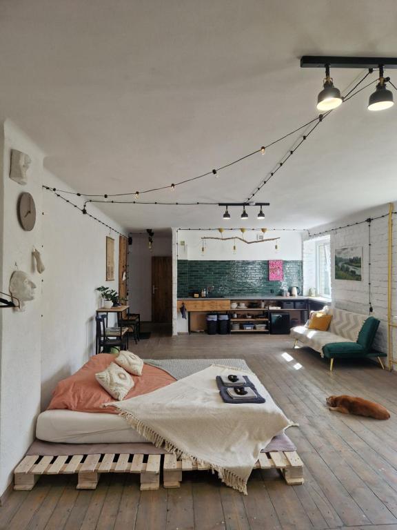 a bedroom with a large bed and a living room at Mākslas studija Koknesē in Koknese