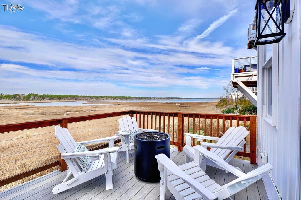 a porch with chairs and a trash can and the beach at Dog Friendly | Waterfront | Surf City, NC | 2 Master Suites | Elevator in Surf City