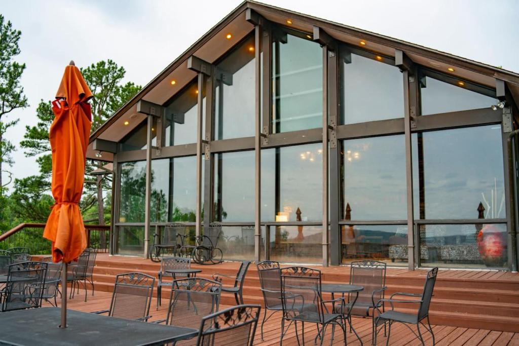 un edificio con mesas, sillas y sombrilla en The Ozark Deck House, en Eureka Springs