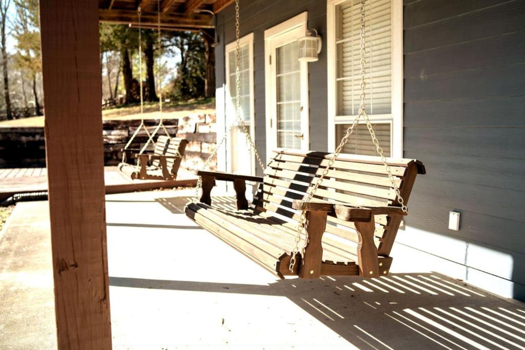 two wooden benches on the porch of a house at Large 6BR Home on White River, WiFi, Sleeps 12 in Eureka Springs