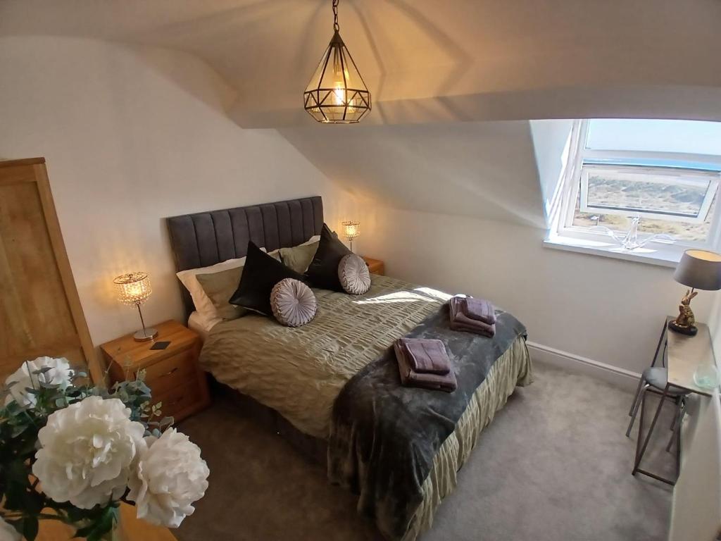 a bedroom with a bed and a window at Seashell Apartment in Barmouth