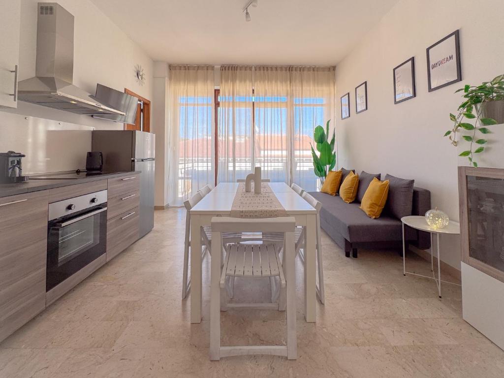 a kitchen and living room with a table and a couch at Vittorio Veneto - Spacious and Bright by Host Hero in Civitanova Marche