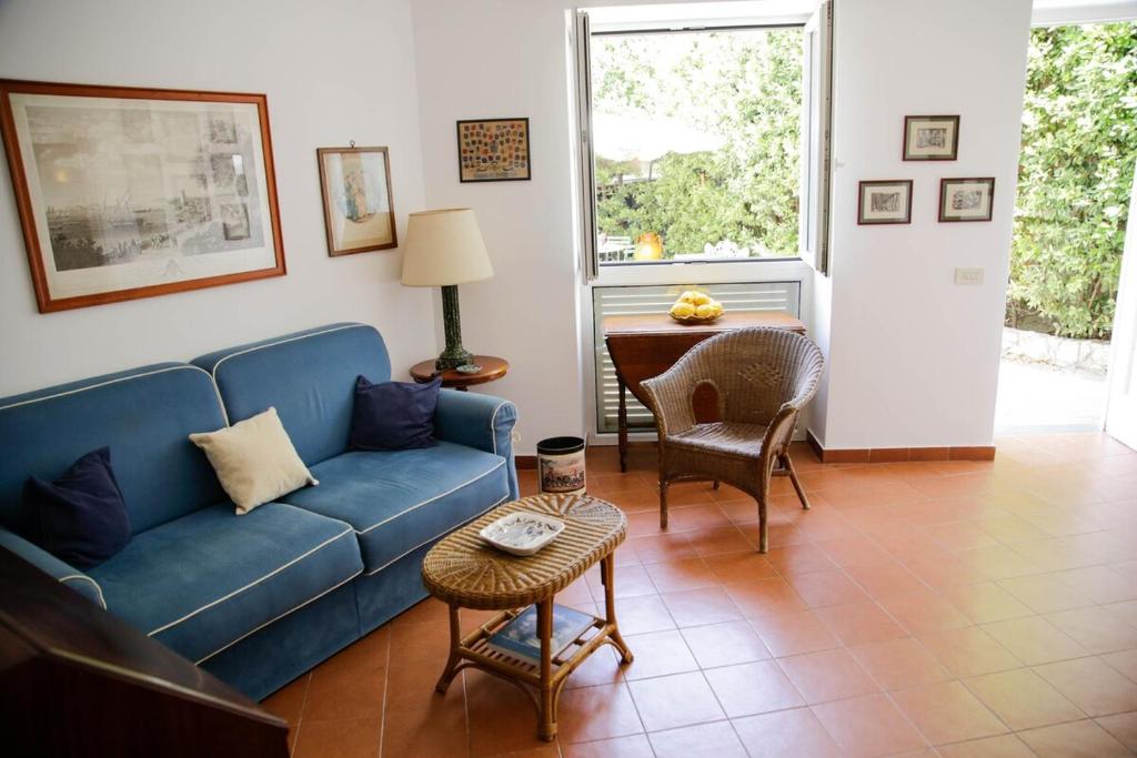 Una sala de estar con un sofá azul y una mesa. en Lemon Grove, en Marina Grande
