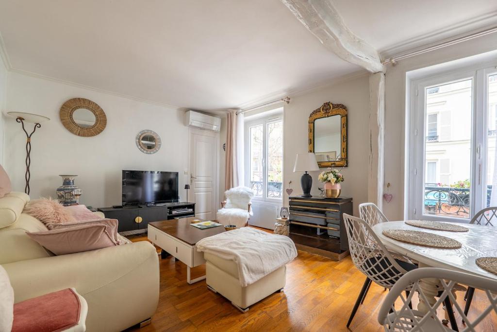 un salon avec un canapé et une table dans l'établissement Heart of Montmartre Air conditioned apartment, à Paris
