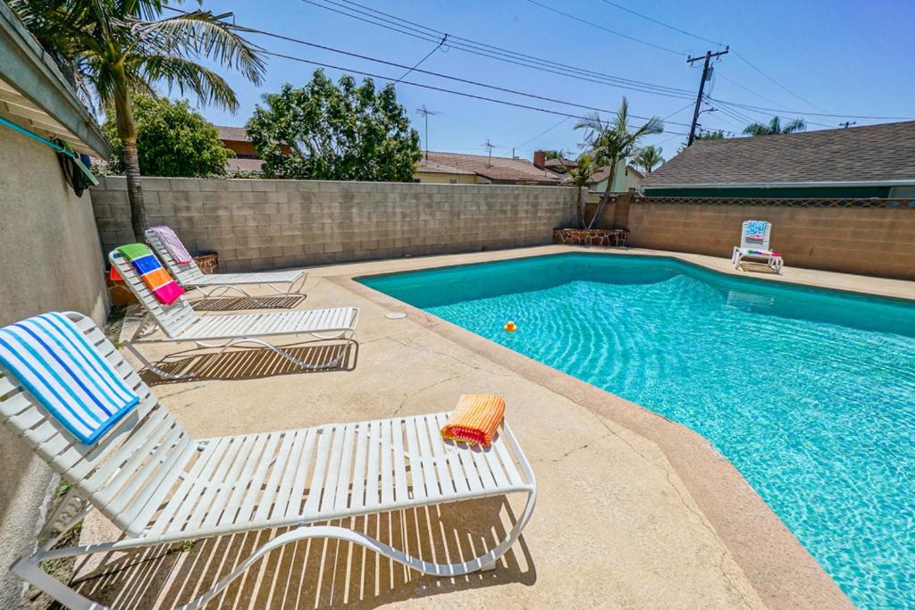 a swimming pool with two lawn chairs next to a swimming pool at F-66 Poolside Retreat in Anaheim