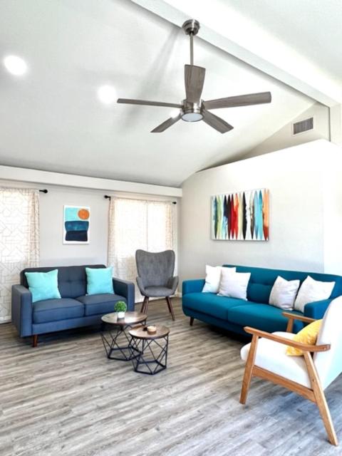 a living room with blue couches and a ceiling fan at F-65 Adventure House in Anaheim