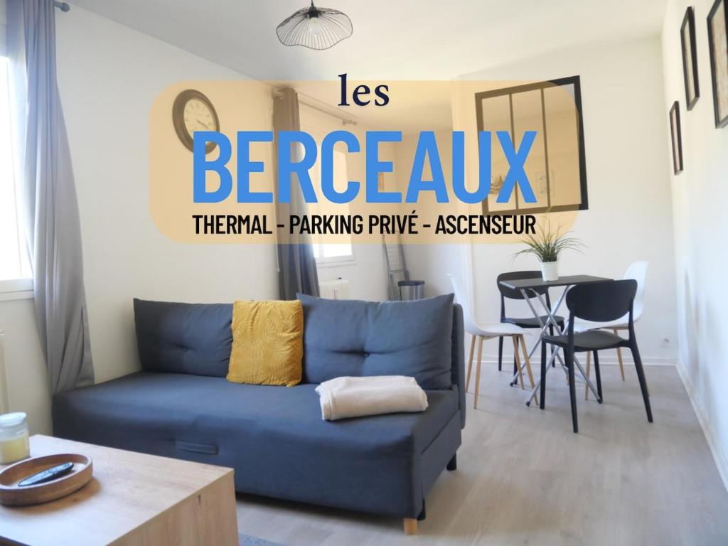 un salon avec un canapé bleu et une table dans l'établissement Les Berceaux Thermal & Parking privé, à Royat