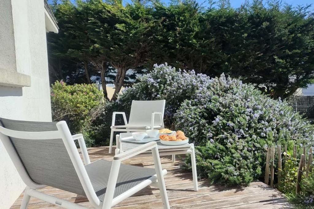 - une table et des chaises avec un ordinateur portable dans l'établissement Villa Garenne Bord de Mer - plage 1 minute à pied, à Quiberon