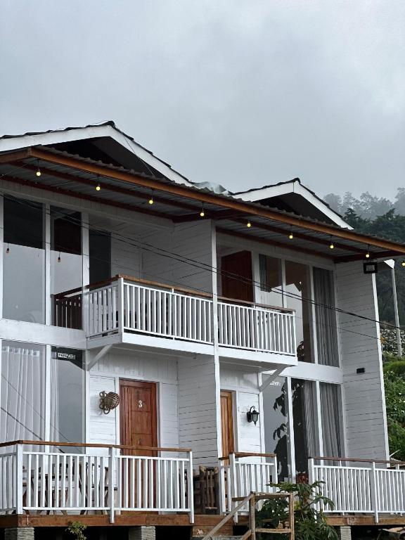 a white house with a porch and a balcony at Aruna Dieng in Dieng