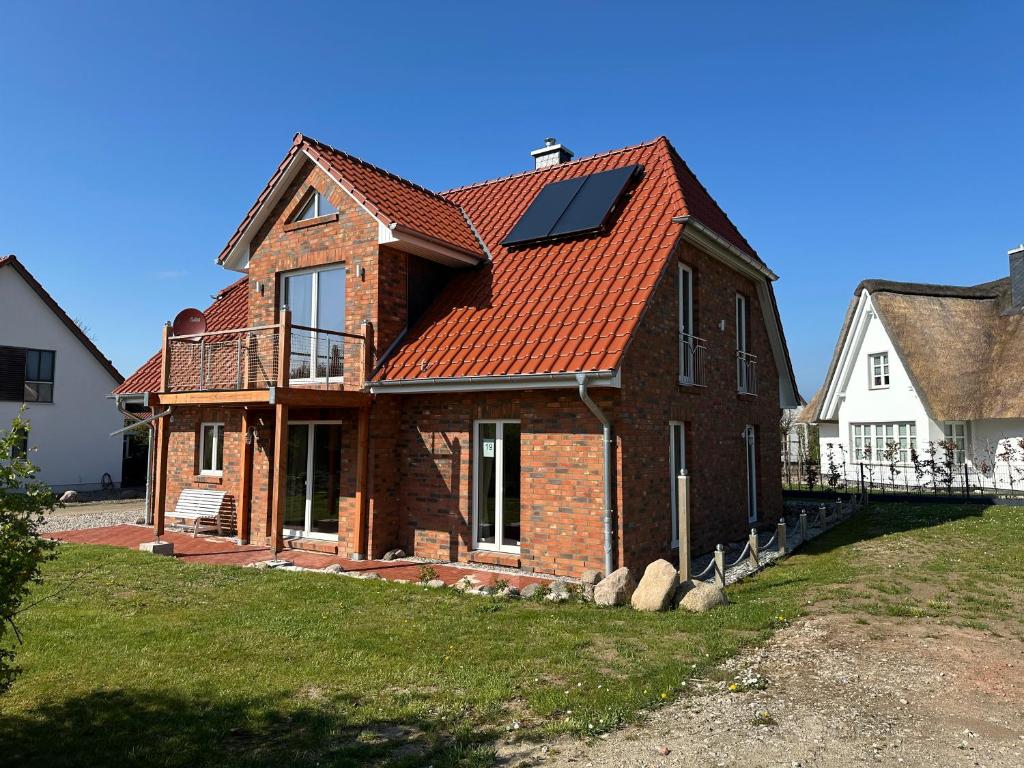 ein Haus mit einem orangefarbenen Dach mit einem Solarpanel in der Unterkunft Seestern in Dassow