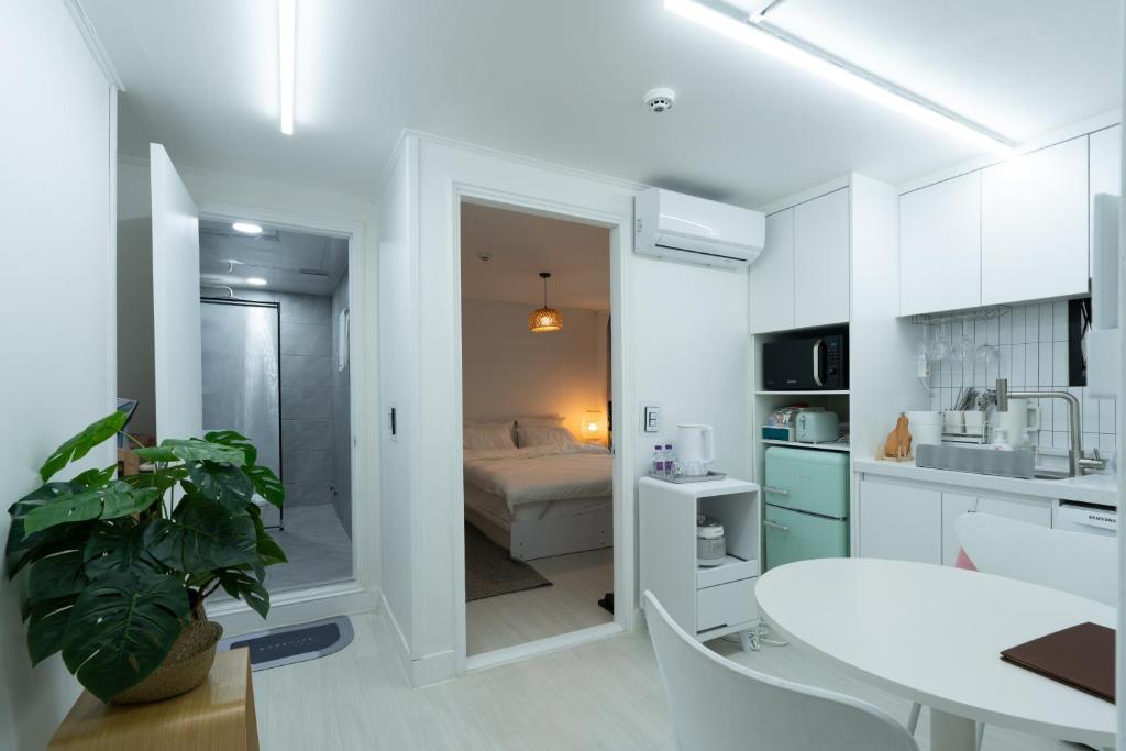 a white kitchen with a white table and a bed at Forest Hangang in Seoul