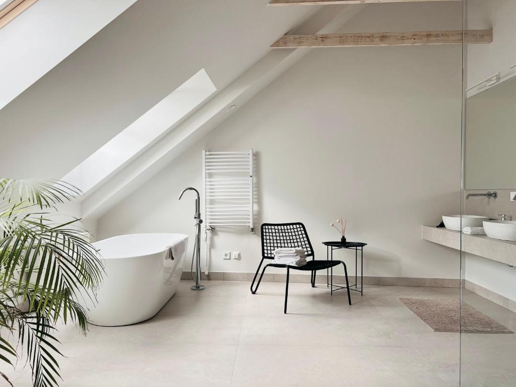 een badkamer met een bad en een stoel bij Vilnius Apartments & Suites – Old Town in Vilnius