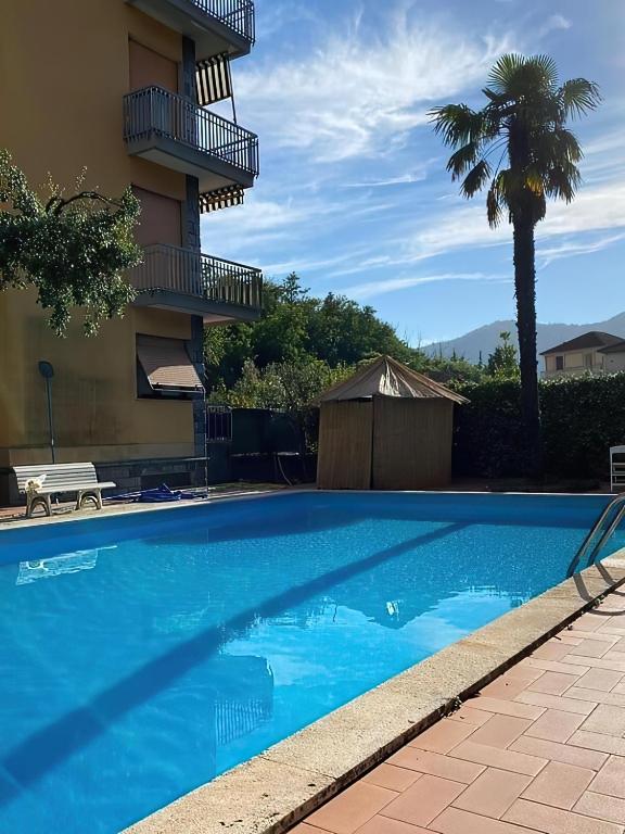 a blue swimming pool in front of a building at AliRiHome in Rapallo