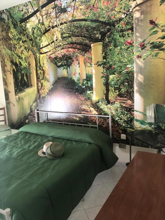 a bedroom with a green bed with a hat on it at CASA NINETTA in Bari