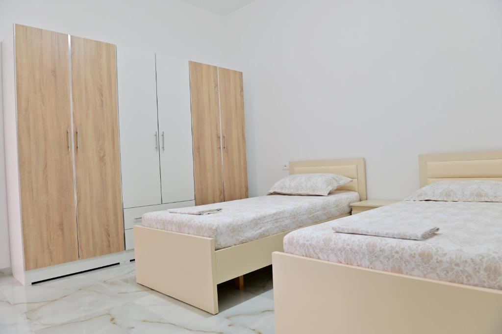 a bedroom with two beds and a wardrobe at Ferienhaus Qelia in Durrës