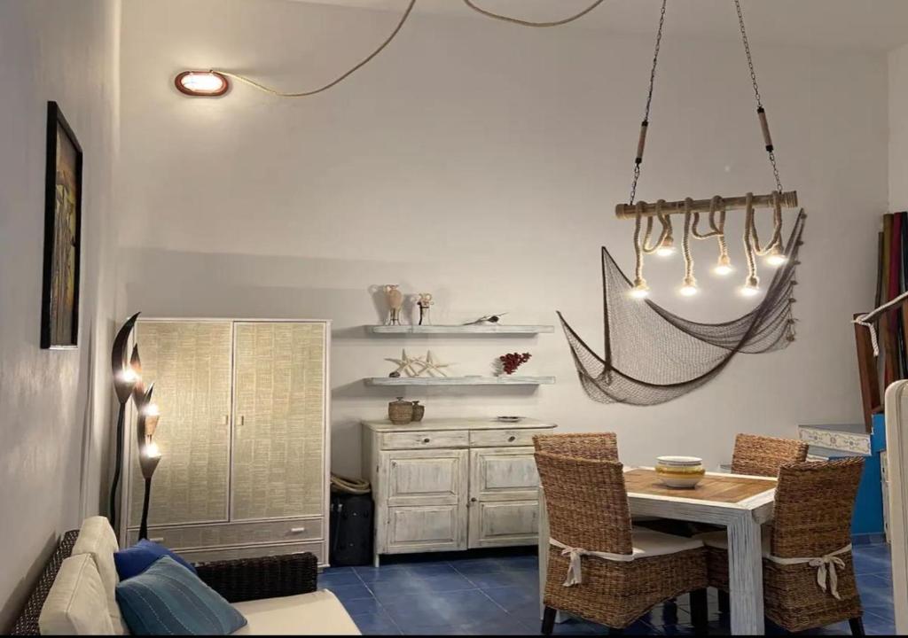 a kitchen with a table and chairs and a chandelier at Casa Ada - Incantevole loft in centro in Lampedusa
