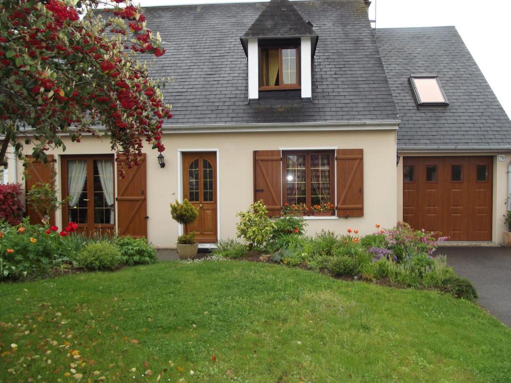 a house with brown doors and a yard at Chambres d'hôtes La Poudrière in Argentan