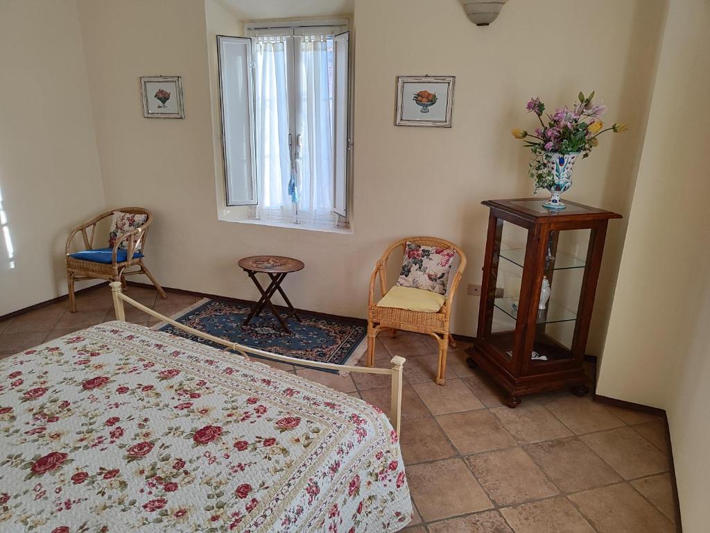 Un dormitorio con una cama y dos sillas y una ventana. en Appartamento Cardellini 1, en Pescia