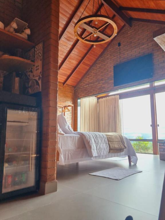 a living room with a fireplace in a brick wall at Chalé HOSPEDAGEM in Rio Bananal