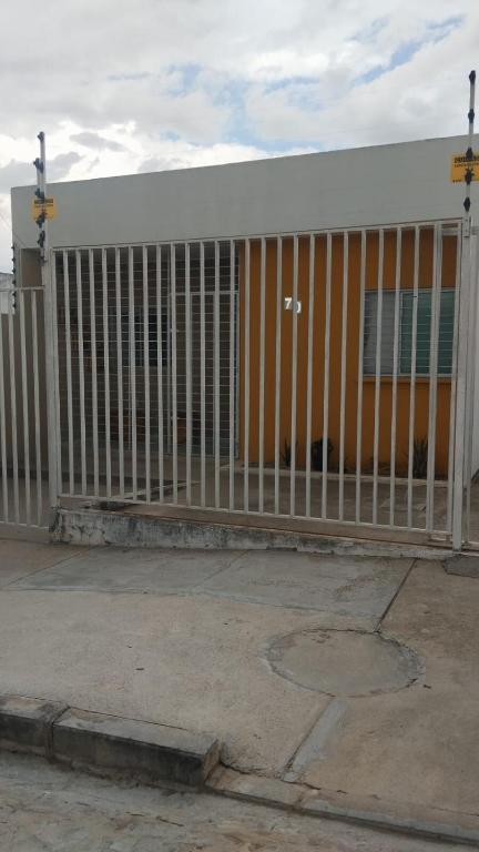 Casa Cida PARA SAO JOÃO في كاروارو: سياج برتقالي وأبيض أمام مبنى