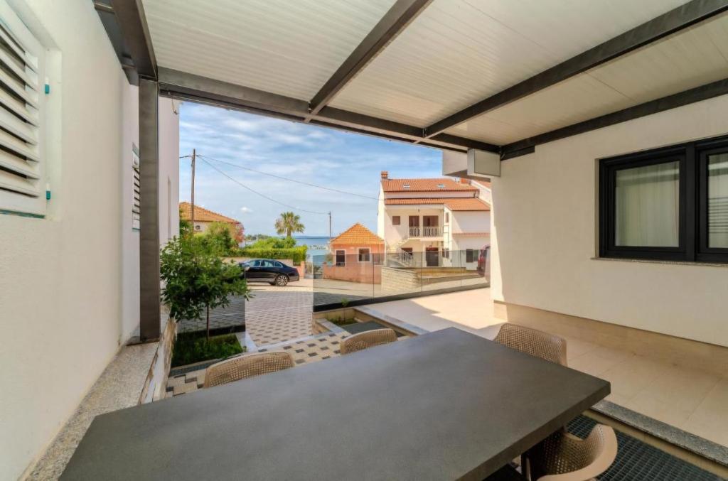 a patio with a table and chairs on a balcony at Villa Oliva Petrcane in Petrcane