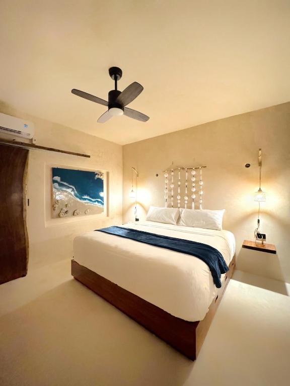 イスラ・ムヘーレスにあるCasa rocaの天井ファン付きの大きなベッドのある寝室