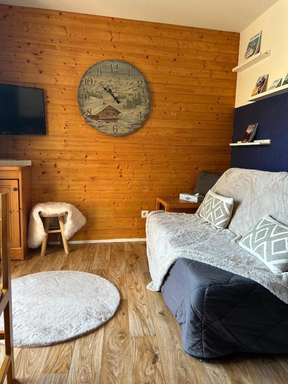 - une chambre avec une horloge sur le mur et un lit dans l'établissement Appartement Chamrousse, à Chamrousse