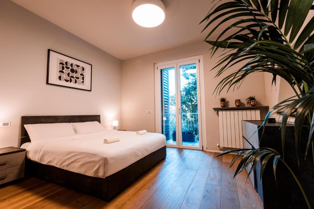 ベルガモにある2' Città Alta - Loft Moderno in Borgo Storicoのベッドと鉢植えのある寝室