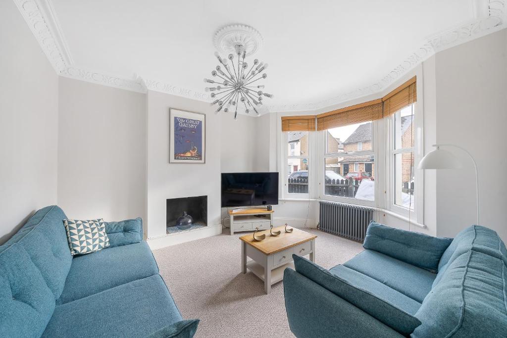 a living room with two blue couches and a tv at Beautiful Large Bedrooms in South Norwood