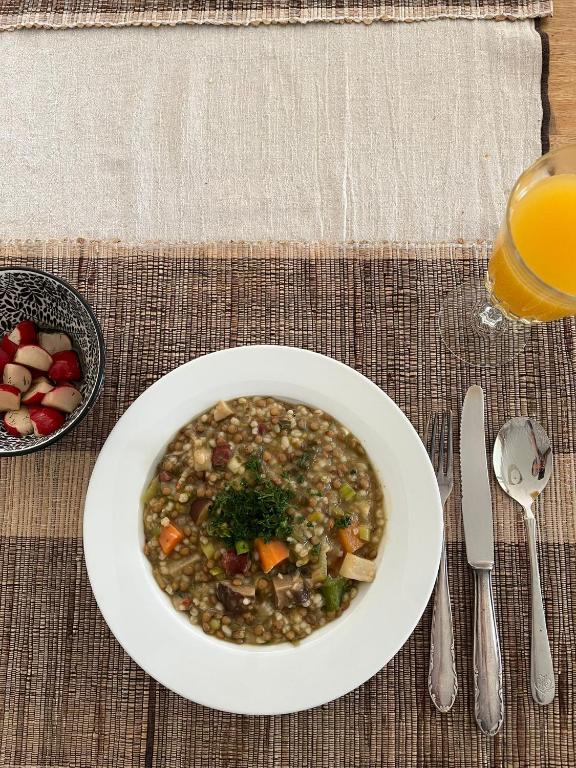 a bowl of soup and a glass of orange juice at Dingqin'Home in Arni Alp
