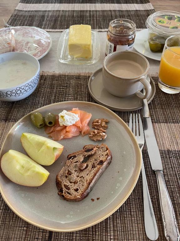 a plate of food with a piece of bread and fruit at Dingqin'Home in Arni Alp