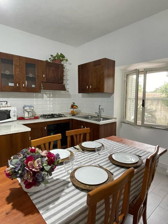 a kitchen with a table with four chairs and a kitchen with a tableablish at La casa di Nenni in Santa Giusta