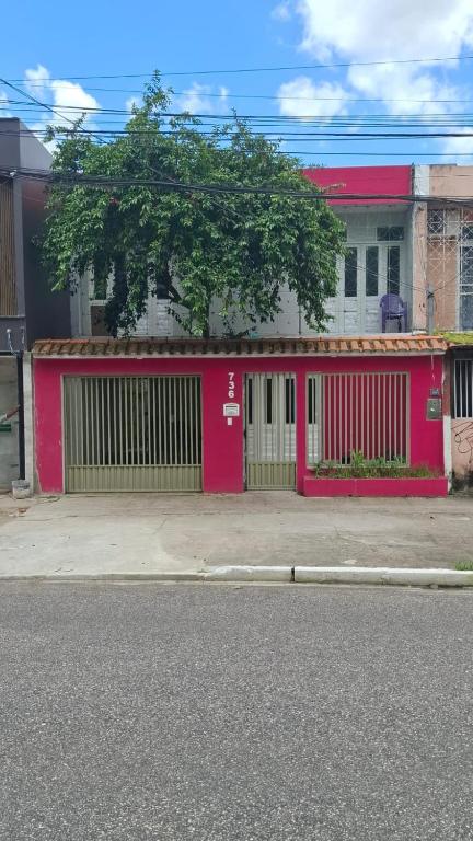 a red building with a gate on a street at Recanto Paraense in Belém