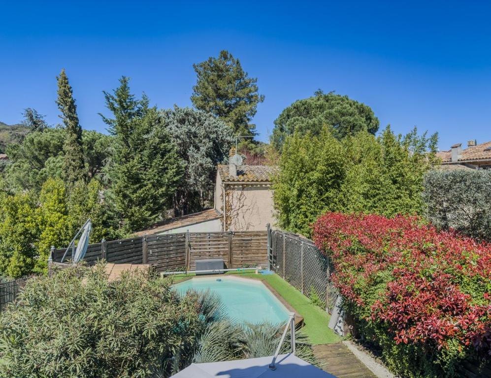 a swimming pool in a garden with flowers at Nouveauté, maison avec piscine in Collobrières