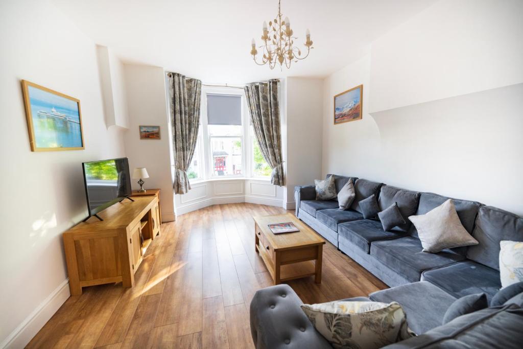 a living room with a couch and a tv at Cosy Llandudno Apartments in Llandudno