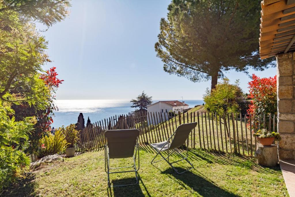 une cour avec deux chaises et une clôture dans l'établissement LA PERLE Bellavista, à Menton