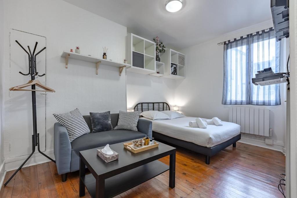 un salon avec un lit, un canapé et une table dans l'établissement Cozy studio near Montparnasse, à Paris