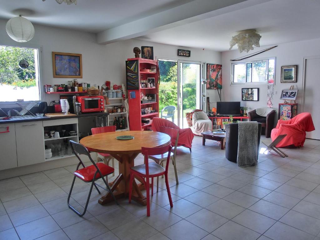 une cuisine et un salon avec une table et des chaises dans l'établissement Ty Chaméléon, à Trégastel