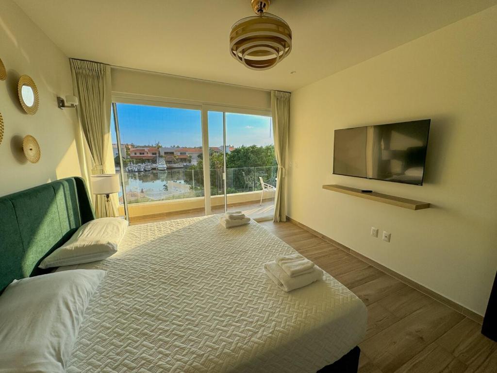 une chambre avec un grand lit et une grande fenêtre dans l'établissement Azure Caribbean Green Spirit, à Puerto Aventuras
