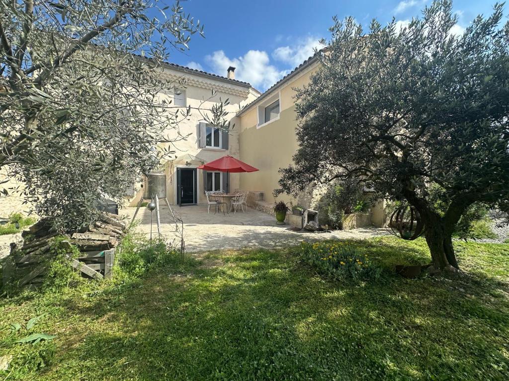une maison avec une table et un arbre dans la cour dans l'établissement SouthCorner - Le Coin du Sud, à Malaucène
