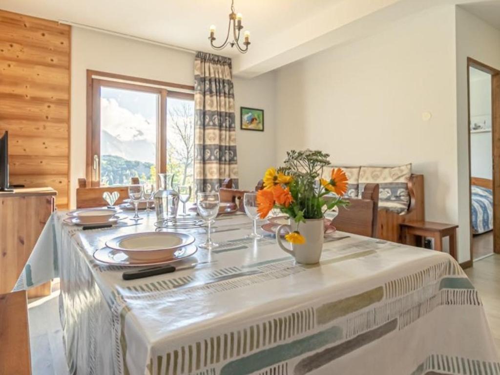 - une salle à manger avec une table et des fleurs dans l'établissement Appartement confortable 6 pers avec terrasse et internet à Aussois - FR-1-508B-5, à Aussois