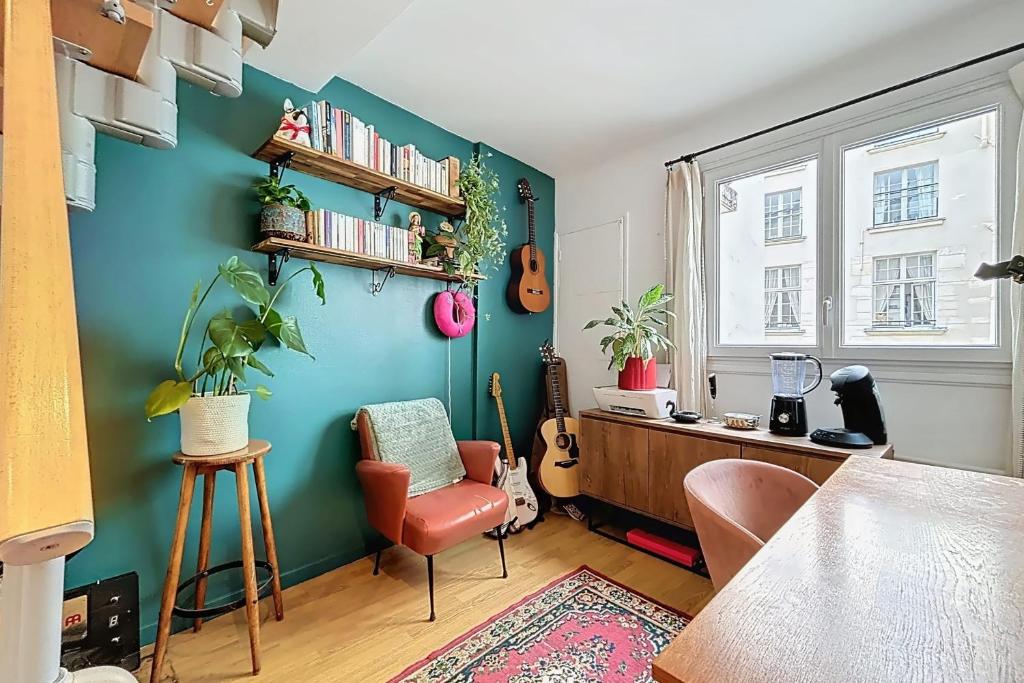 Cette chambre est dotée d'un mur bleu, d'un bureau et d'une chaise. dans l'établissement Cosy duplex close to Notre Dame, à Paris