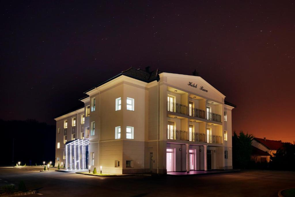 a large white building at night at Hotel Raca in Sesvete